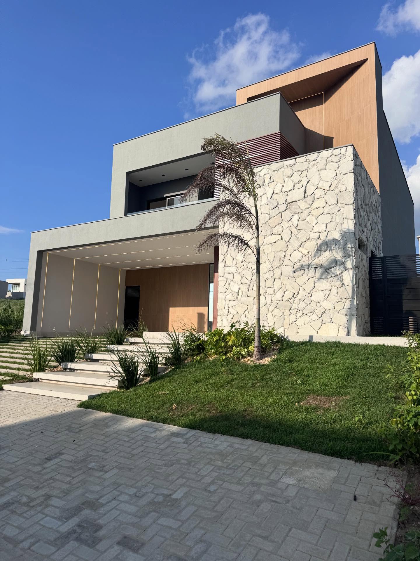 Fachada contemporânea com pedra natural e madeira